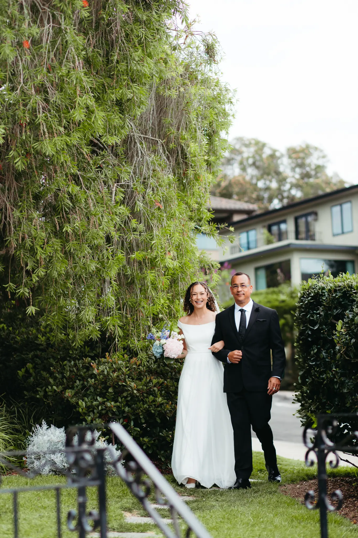 Kalea walks through The Thursday Club garden in Point Loma on her wedding day